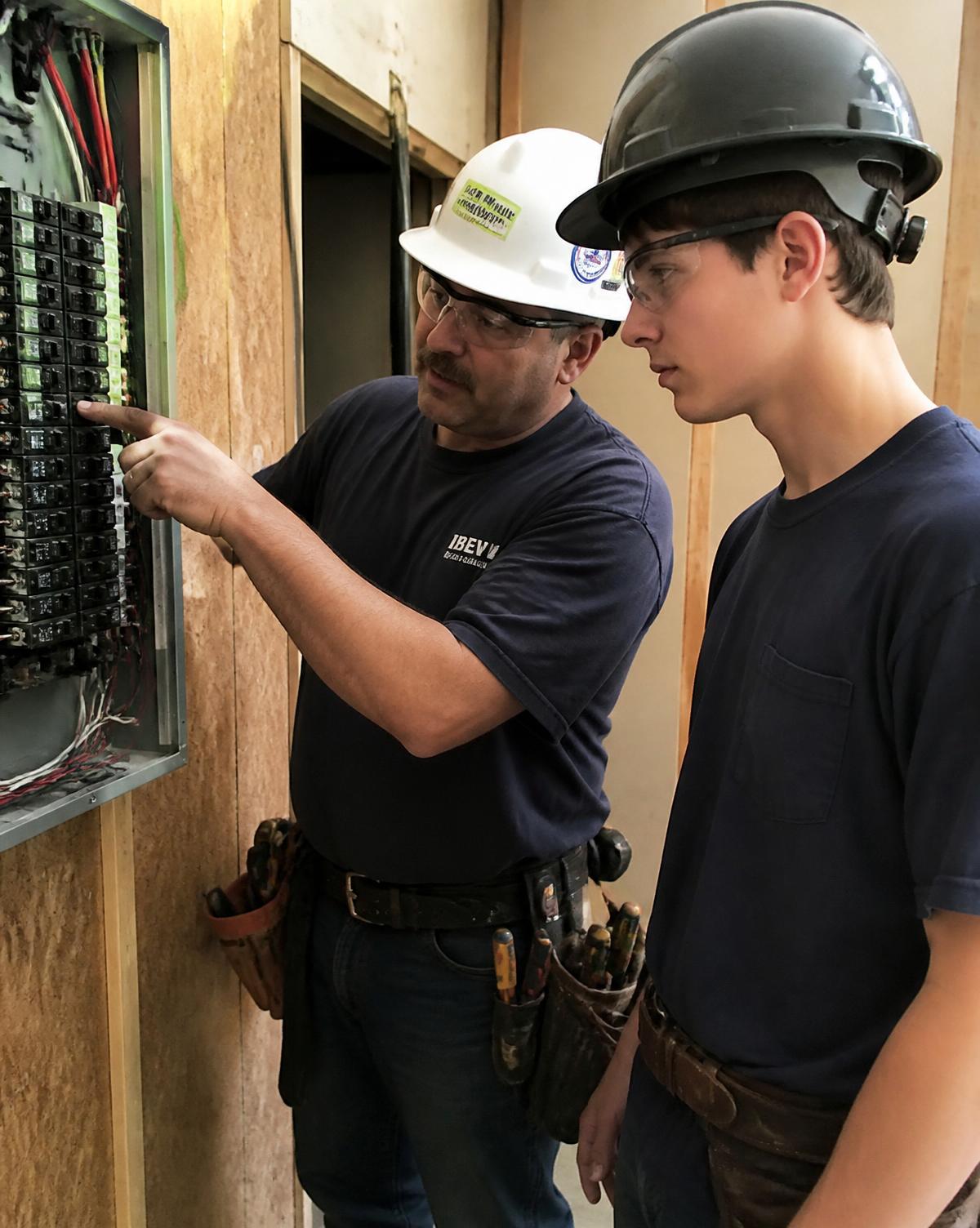 An electrician working on a panel
